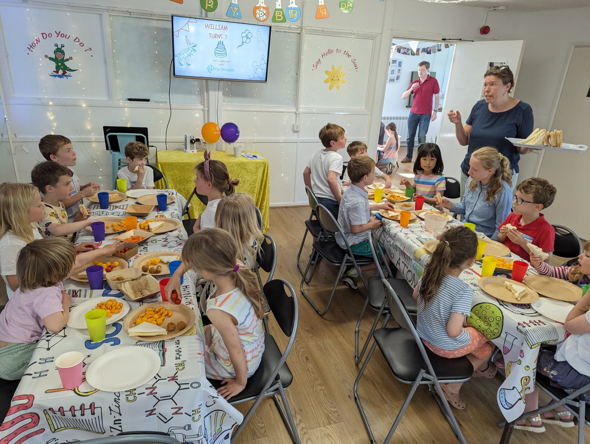 Children enjoying their party food at science themed tables