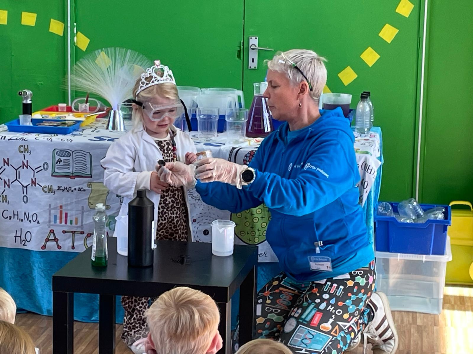Professor Lee with a birthday child wearing a lab coat and tiara